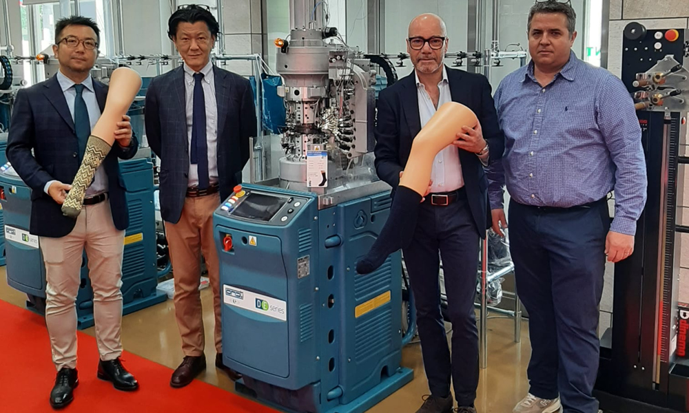 Gruppo di persone con nuova macchina DC88 DE 2H2 presentata in Giappone