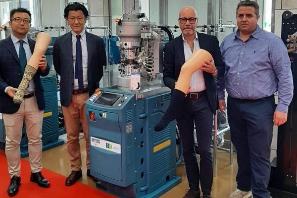 Gruppo di persone con nuova macchina DC88 DE 2H2 presentata in Giappone